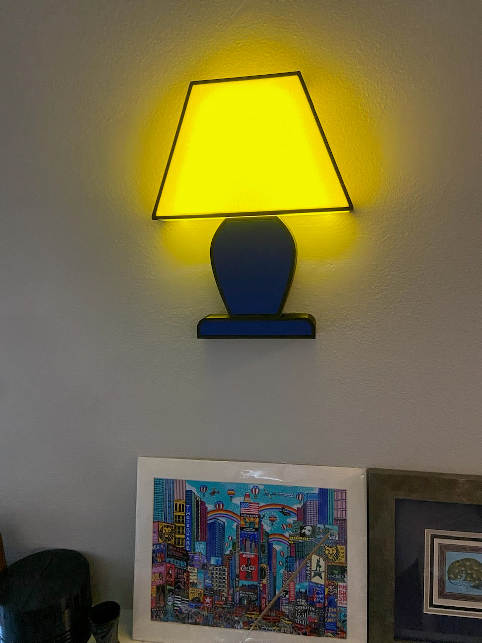 Iconic 2D Wall Lamp, Yellow/Blue, mounted on a wall and turned on